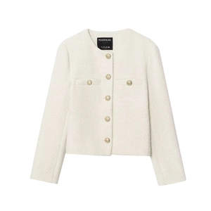 Detail of white tweed jacket featuring textured weave and golden embossed metal buttons