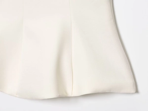 Detailed view of white fabric texture and flared hemline of women camisole top