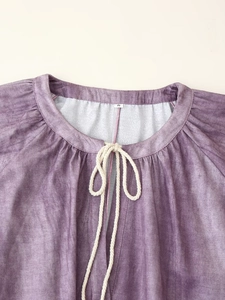 Detail of round neckline with white braided ties and size S label on purple linen dress