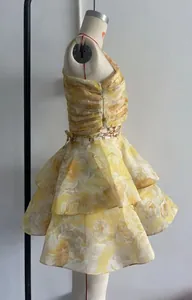 Vue détaillée d'une robe fleurie jaune avec volants superposés et bustier froncé