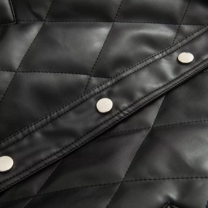 Detail of diamond quilted black PU leather with three silver metal snap buttons