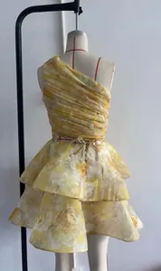 Détail de robe fleurie asymétrique avec plis horizontaux et ourlet à volants étagés