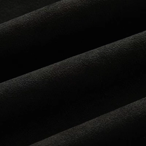 Gros plan sur le tissu en daim noir de la veste de moto avec une texture veloutée douce