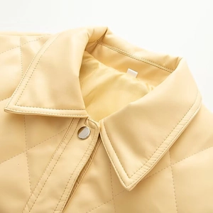 Detail of quilted faux leather jacket showing a turn-down collar and silver snap buttons