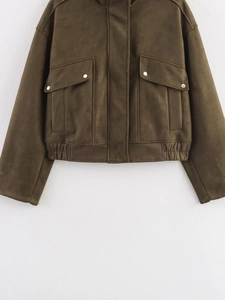 Détail de la veste en daim vert olive avec poches à rabat et boutons-pression en métal
