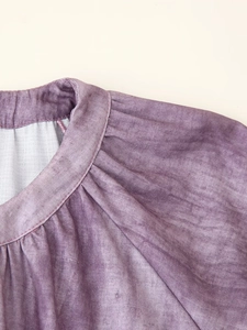 Close-up of mauve linen blend dress featuring gathered shoulders and a band collar detail