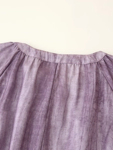 Detail of round neckline with marble tie-dye print on linen-textured purple dress