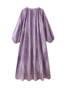 Close-up of lightweight linen-blend fabric with purple tie-dye stripes on a loose dress