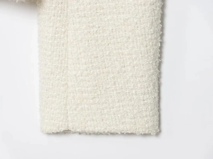Macro detail of high-quality white tweed fabric texture and woven edge of the jacket