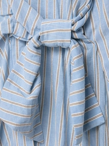 Detail of blue and white striped dress fabric with a waist tie knot and cotton texture