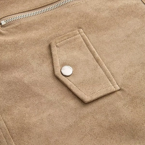 Détail d'une veste en daim marron avec fermeture éclair en métal et coutures lisses