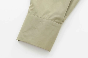 Detail of sleeve cuff on sage green poplin shirt with high-density cotton stitching