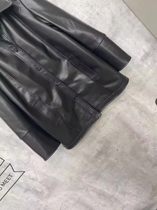 Detail of black faux leather jacket texture with single-breasted buttons and pockets
