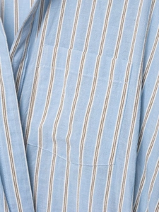 Detail of light blue striped cotton fabric showing fine texture and pocket stitching