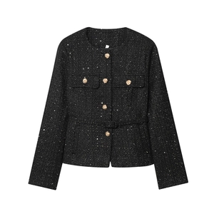 Close-up of black tweed jacket featuring gold sequins and elegant metallic buttons