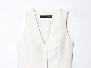Détails de la veste blanche à col en V avec coutures ajustées et fermeture à bouton