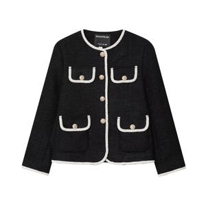 Detail of tweed jacket featuring white braided trim and golden lion-embossed buttons