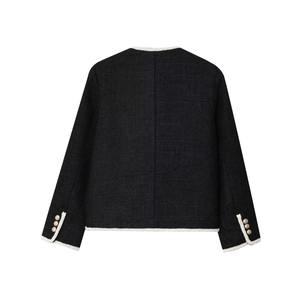 Detail view of black tweed jacket featuring white braided trim and golden buttons on cuffs