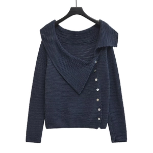 Detailed view of dark blue knit cardigan featuring off-the-shoulder collar and white buttons