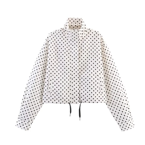 Detail of high neck polka dot jacket showing drawstring hem and crisp white windbreaker fabric