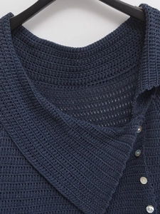 Detail of navy blue crochet cardigan showing textured knit patterns and pearl buttons