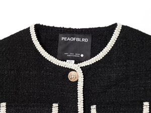 Close-up of a tweed jacket featuring white woven trim and a vintage golden button detail