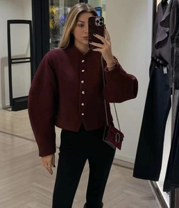 Detailed close-up of wine red wool blend jacket with silver buttons and lantern sleeves