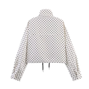 Detail of female white polka dot jacket back featuring stand collar and drawstring hem