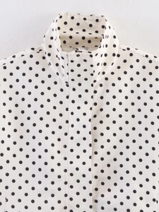 Close-up of stand collar and fabric detail on black polka dot white jacket