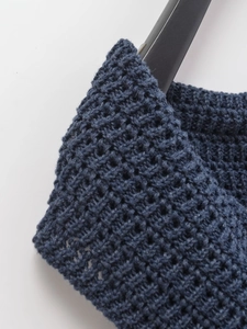 Detailed macro view of dark blue chunky knit fabric with openwork crochet texture