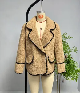 Détail de la veste en polaire camel avec revers et bordures contrastées noires