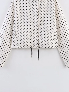 Detailed view of polka dot jacket featuring adjustable drawstring hem and side pockets