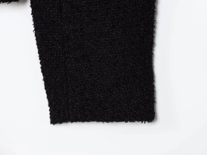 Close-up of the black tweed fabric texture with high-quality fiber weave details