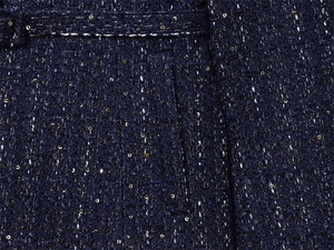 Macro shot of navy tweed fabric with silver interlaced threads and golden sequins