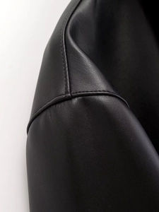 Close-up of premium black leather jacket with detailed stitching and lychee grain texture