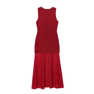 Detail of red sleeveless midi dress showing knitted bodice and pleated skirt texture