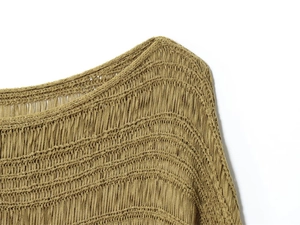 Close-up of mustard yellow knit sweater featuring hollow mesh and vertical tassel texture