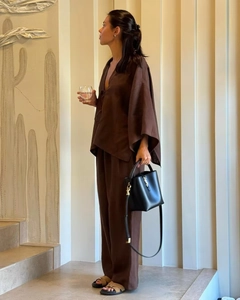 Détail d'un ensemble ample marron foncé avec haut col V et pantalon large en lin mélangé