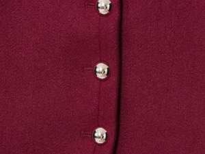 Detail of silver metallic buttons on burgundy wool textured jacket with twill weave