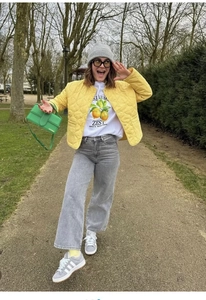 Detail of yellow quilted jacket paired with a graphic lemon tee and green handbag
