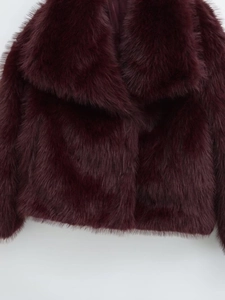 Close-up detail of smooth wine red faux fur texture and thick collar on winter coat