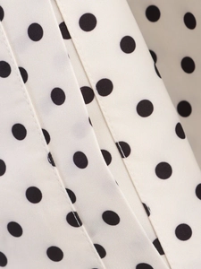 Macro shot of polka dot woven fabric detailing neat stitching on the jacket set
