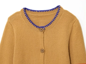Detailed view of brown knit cardigan featuring blue embroidered trim and dark brown buttons