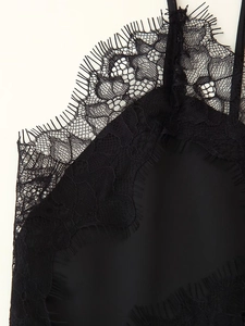 Detailed view of black eyelash lace trim and silk fabric on asymmetrical strap dress