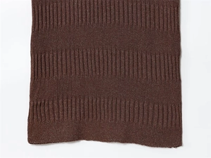 Close-up of dark brown ribbed knit fabric detail on the asymmetrical midi dress