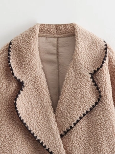 Detail shot of sherpa jacket collar featuring decorative black and white wave pattern piping