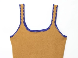 Detailed close-up of camel knit camisole with blue scalloped embroidery on neckline