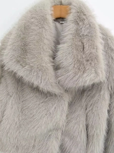 Close-up of grey faux fur coat featuring wide lapels and a size XS woven neck label