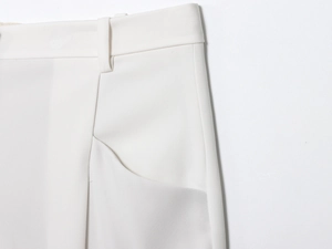 Détail du pantalon blanc à taille haute avec passants de ceinture et coutures précises