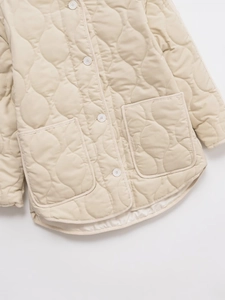 Close-up of beige quilted jacket featuring wave stitching and large front pockets